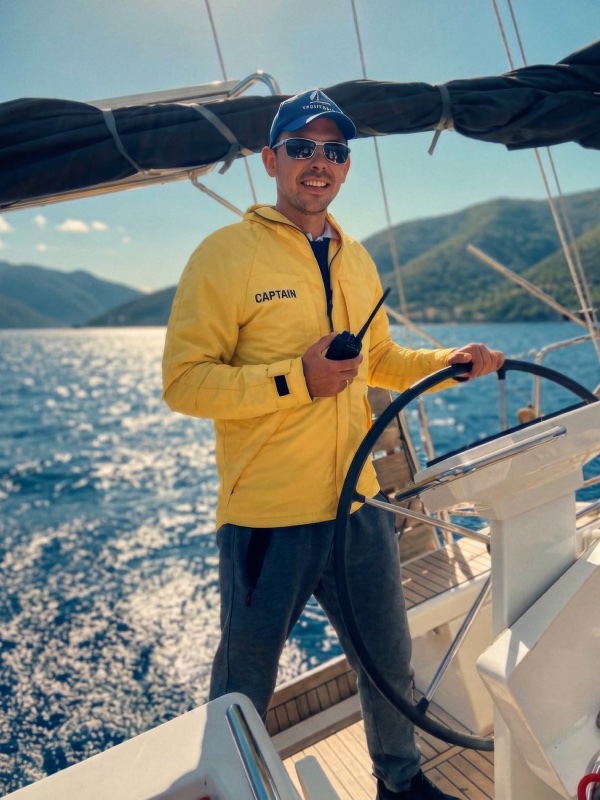 Leo at the helm in a yellow captain&rsquo;s jacket