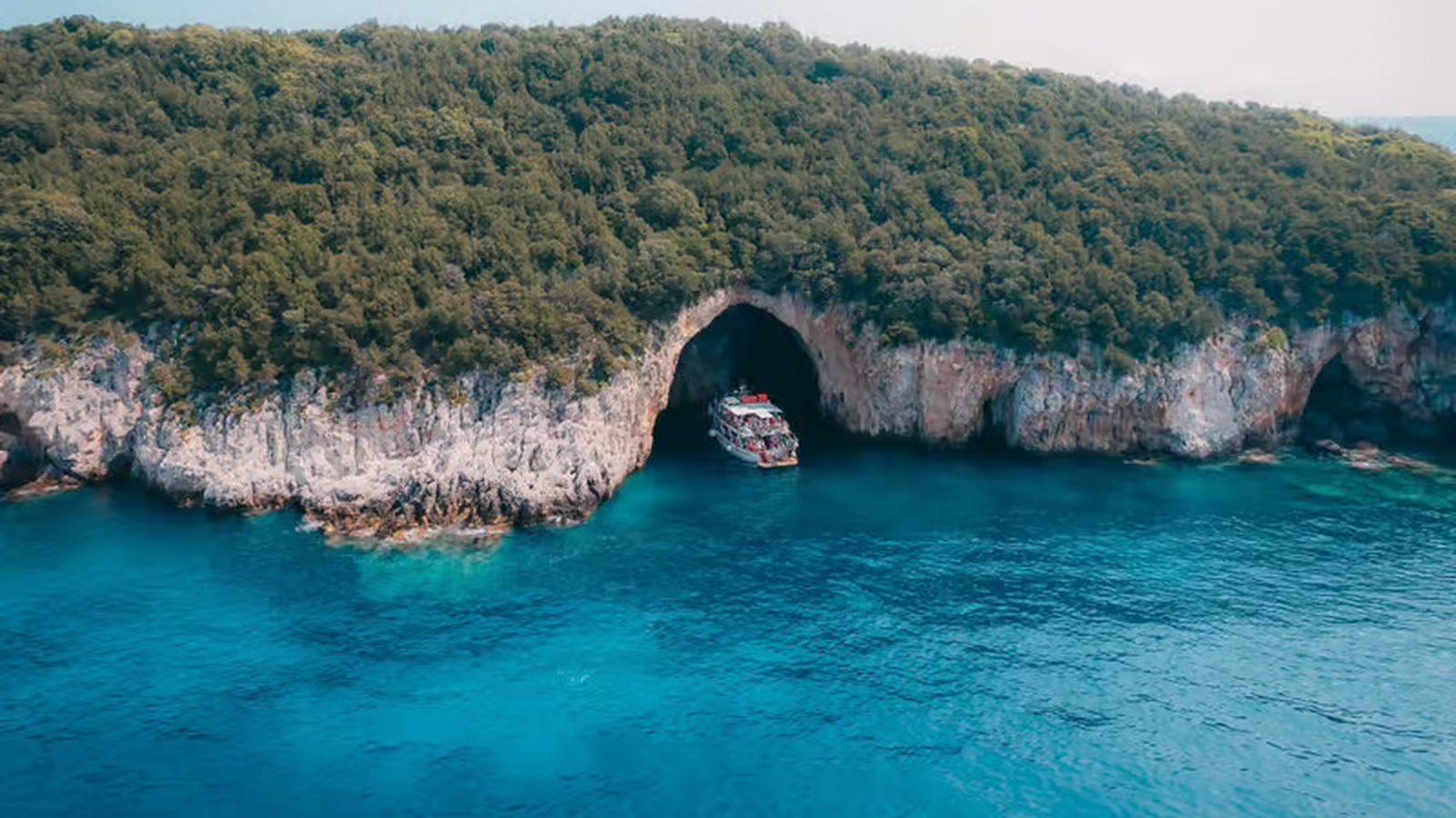 Papanikolis sea cave on the south tip of Meganisi, a boat inside the entrance