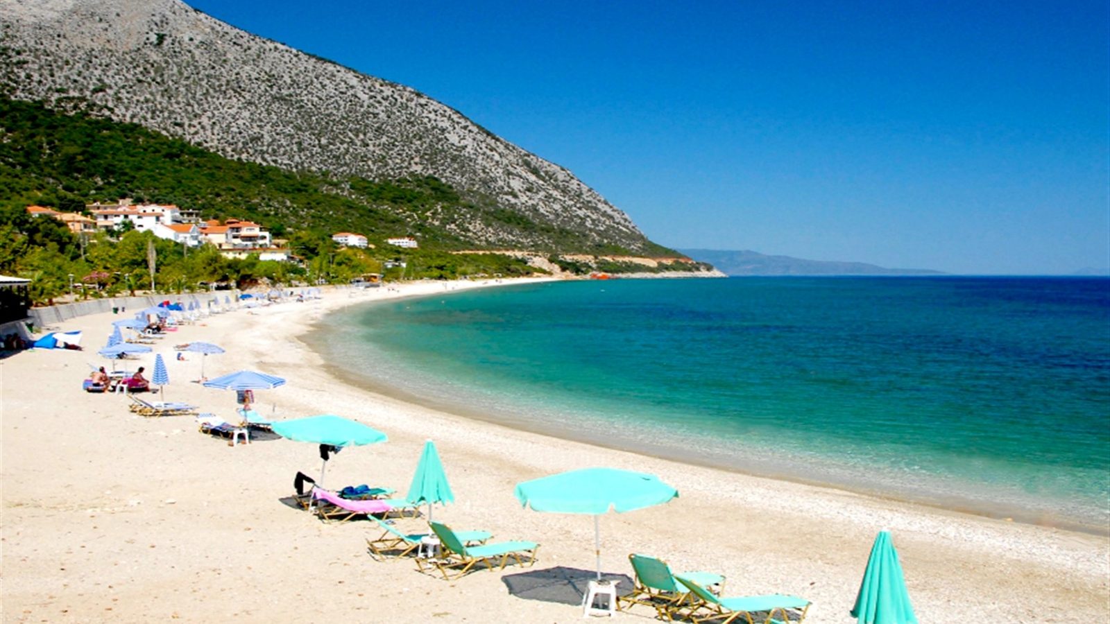 Aragia beach south of Poros, a long white pebble sweep under the mountain
