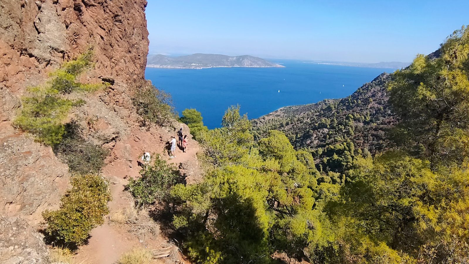 Hikers on the trail up the Methana volcano, the bay far below