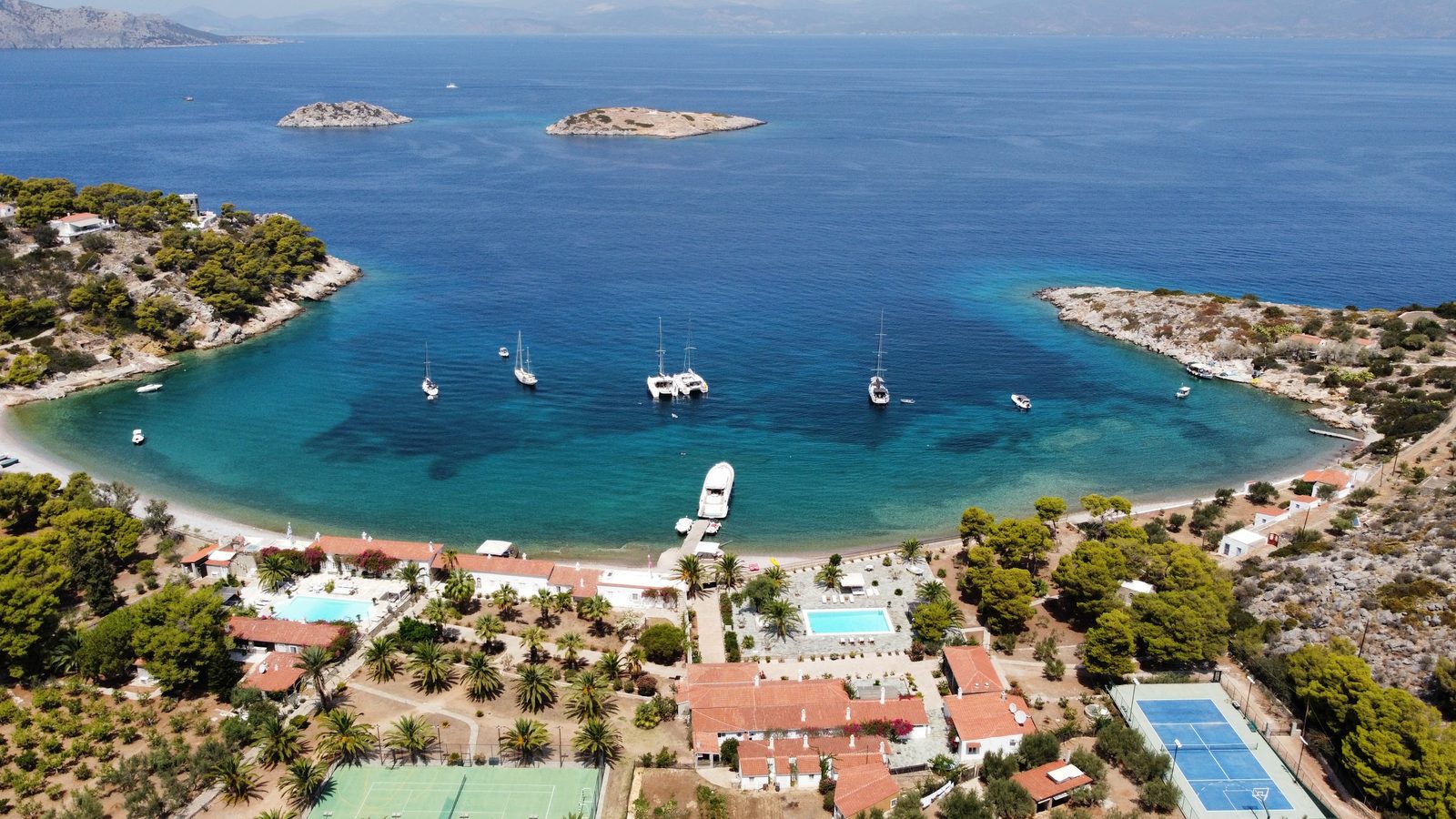 A quiet bay near Hydra from the air, boats at anchor off a pine shore