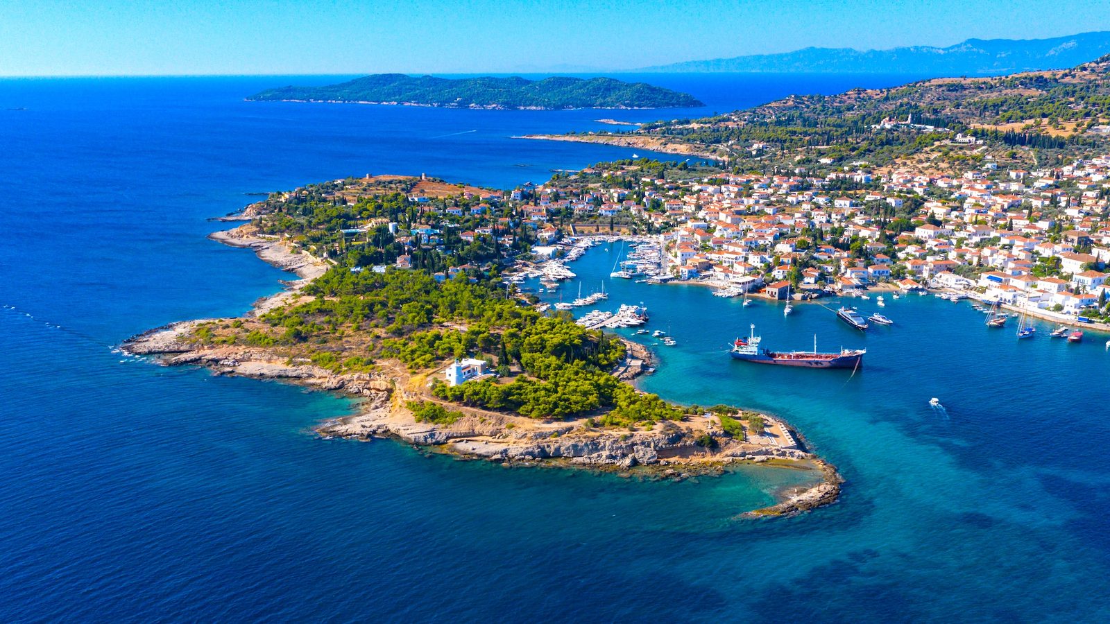 Spetses harbour from the air: the old lighthouse islet and a ship at anchor off the town