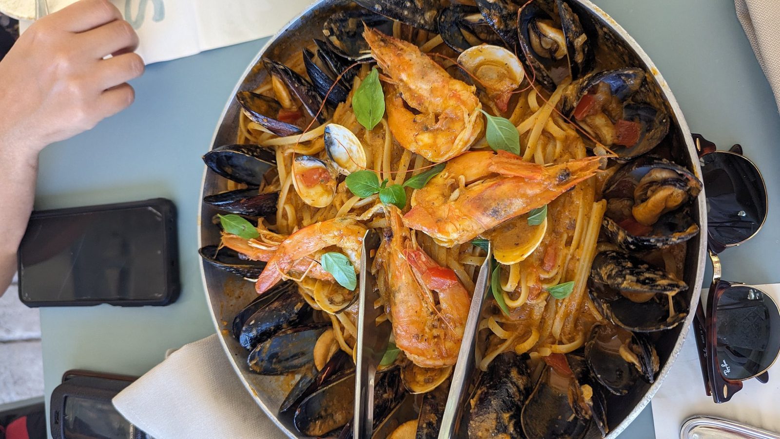 A seafood pasta of mussels, clams and prawns, table by the water