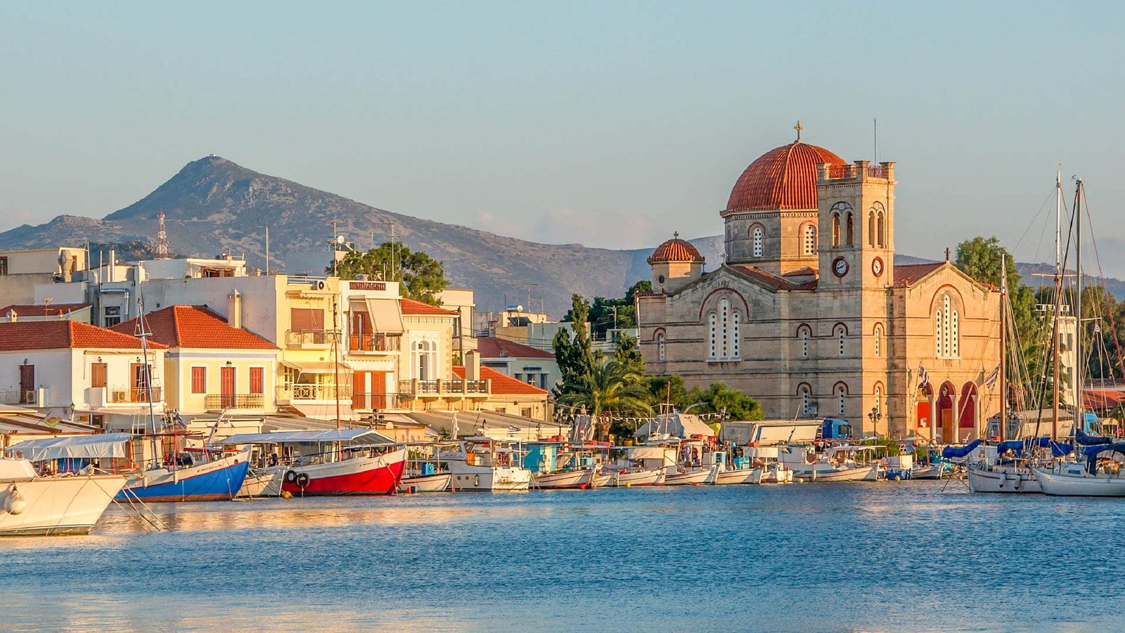 Aegina harbour at sunset, the red-domed church above the fishing boats