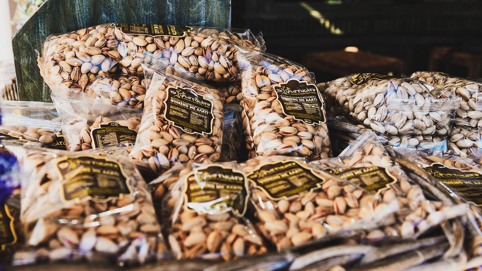 Bags of Aegina pistachios stacked at a quayside shop